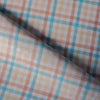 A close-up of the Multi Gingham 100% Linen Fabric showcasing its fine, yarn-dyed plaid pattern in blues, peaches, and creamy oatmeal