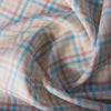 A close-up of the Multi Gingham 100% Linen Fabric showcasing its fine, yarn-dyed plaid pattern in blues, peaches, and creamy oatmeal