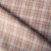 Earthy plaid linen fabric with vivid pumpkin threads and natural texture, suitable for creating comfortable and stylish wardrobe staples.