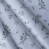 Soft green foliage patterns on white Leafy Whisper Linen Blend Fabric, 160 GSM, ideal for eco-friendly fashion and décor.