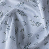 Soft green foliage patterns on white Leafy Whisper Linen Blend Fabric, 160 GSM, ideal for eco-friendly fashion and décor.