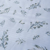 Soft green foliage patterns on white Leafy Whisper Linen Blend Fabric, 160 GSM, ideal for eco-friendly fashion and décor.