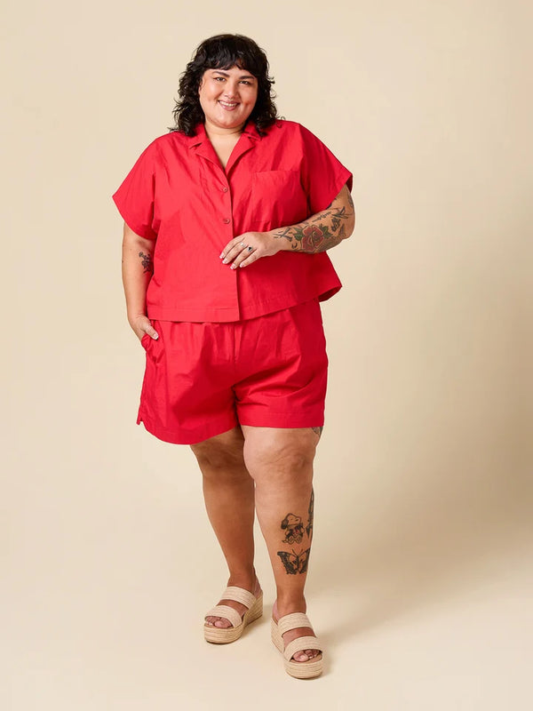 Person wearing a red outfit on a beige background