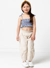 Kids’ shirred crop top with rouleau straps and balloon pants with ruffle and pockets sewing pattern, ideal for light woven fabrics.