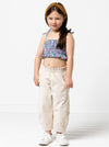 Kids’ shirred crop top with rouleau straps and balloon pants with ruffle and pockets sewing pattern, ideal for light woven fabrics.