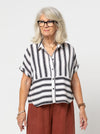 Lady wearing a black and white striped shirt made with the Blaire Shirt Sewing Pattern – Square-shaped with rolled cuffs and overlay.