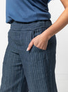 close up view of lady wearing blue stripped linen pant made using Fifi Woven Pant sewing pattern, featuring a wide leg design with a smooth front yoke, elastic back, and side pockets, perfect for crepe, linen, and rayon fabrics.