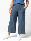 front view of lady wearing blue stripped linen pant made using Fifi Woven Pant sewing pattern, featuring a wide leg design with a smooth front yoke, elastic back, and side pockets, perfect for crepe, linen, and rayon fabrics.