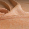 Yarn-dyed Orange Chambray 100% linen fabric in light orange, ideal for lightweight and stylish clothing.