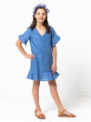 Fun and flirty Pixie Teens Dress sewing pattern featuring an easy-fit A-line shape, short flounce sleeves, hem flounce, and a ‘V’ neck, ideal for various woven fabrics