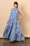 Woman wearing a blue and white patterned dressmade using Azure Dress, Skirt, and Top sewing patternagainst a beige background