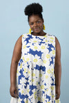 Woman wearing a sleeveless dress with blue and white floral patternmade using Azure Dress, Skirt, and Top sewing patternagainst a light blue background