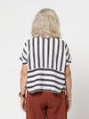 Lady wearing a black and white striped shirt made with the Blaire Shirt Sewing Pattern – Square-shaped with rolled cuffs and overlay.