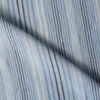 Vintage-style Blue Multi Stripe 100% Linen Fabric with varying stripes in navy, blue, and white on a light blue background, offering a washed-out look.