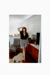 Lady wearing blach ginghamshortsmade of Bottlebrush Pants and Shorts Sewing Pattern - High-Waisted Flared Pants and Mini Shorts