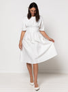 Woman wearing a white dress made using Bronte Woven Dress sewing pattern on a white background