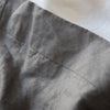 Close-up of gray fabric with a visible seam on a white background
