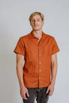 a man weariing terracotta colour shirt made using Finch Men's Shirt Sewing Pattern - Button-Up Shirt with Scoop Back Hem