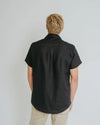 a man weariing black colour shirt made using Finch Men's Shirt Sewing Pattern - Button-Up Shirt with Scoop Back Hem