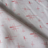 Sheer white 100% linen fabric with delicate red crosshatch print and a loose, elegant weave