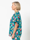 Woman wearing a colorful ice cream patterned shirt against a white background