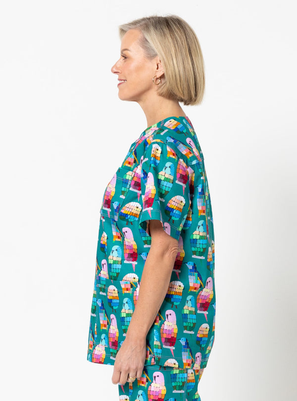 Woman wearing a colorful ice cream patterned shirt against a white background