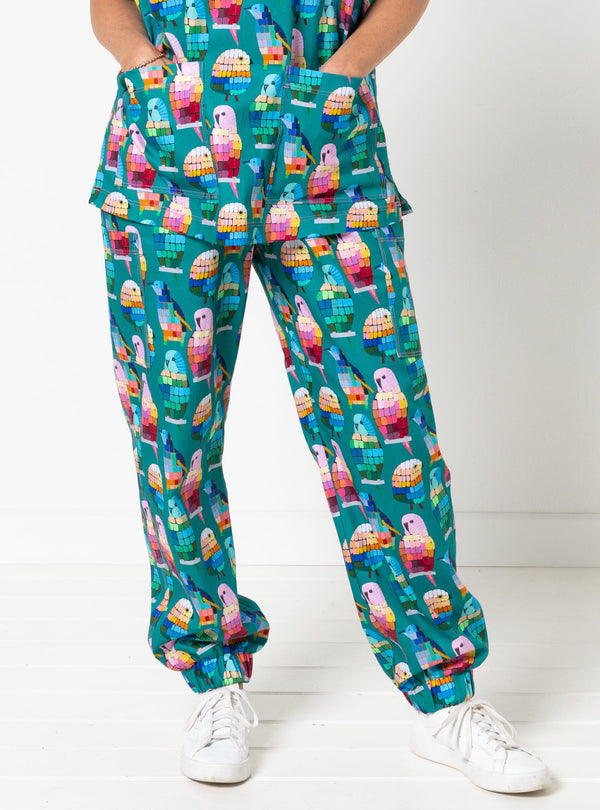 Person wearing teal scrubs with colorful parrot pattern on a white background