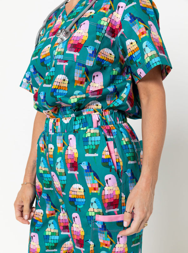 Person wearing a colorful parrot patterned dress on a white background