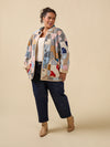 Woman wearing a patchwork jacket with a beige background
