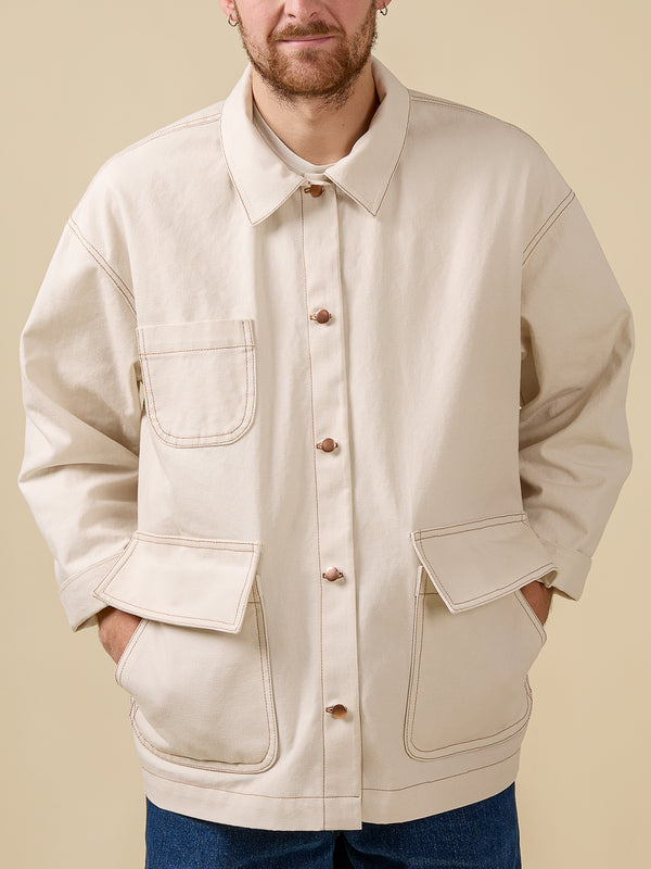 Man wearing a beige jacket with button details on a beige background