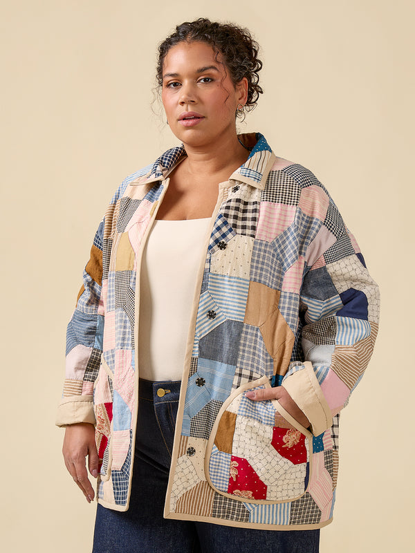 Woman wearing a patchwork jacket on a beige background
