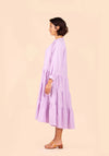 Woman wearing a light purple Poppy Dress against a beige background