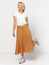 Haven Woven Skirt Sewing Pattern - mid-length skirt with fitted waist, invisible zip, flared hem with curved seams, and shaped waistband.