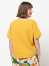 Joan Woven Top sewing pattern featuring a square shape, V-neck, extended shoulder line with band, and wide hem facings, suitable for washed linen, charmeuse, crepe, and rayon fabrics.