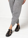 Kew Woven Pant sewing pattern, featuring a waisted, fly front design with a shaped leg, unique hem, and angled pockets, suitable for linen, fine wool, or crepe fabrics.