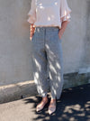 Kew Woven Pant sewing pattern, featuring a waisted, fly front design with a shaped leg, unique hem, and angled pockets, suitable for linen, fine wool, or crepe fabrics.