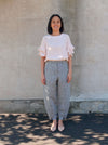 Kew Woven Pant sewing pattern, featuring a waisted, fly front design with a shaped leg, unique hem, and angled pockets, suitable for linen, fine wool, or crepe fabrics.