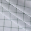 Mossy Grid linen-cotton blend fabric with a white base and moss-colored grid, lightweight and sheer with a loose weave.