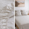 Close-up of textured Natural linen fitted sheet soft beige bedding in a neatly made bed with light-colored bedding.