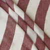 A close-up of Rosewood Broadstripe fabric with alternating wide bands of dusty rose red and warm off-white, showing a textured woven surface.