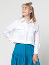 lady wearing white jacket made using Smith Woven Jacket with buttoned fly front, square shape, full-length sleeves with tabs, front pockets, and back pleat, made from linen fabric.