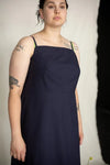 Woman wearing a navy blue dress against a plain background