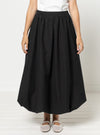 Person wearing a black skirtmade using Sophia Woven Bubble Skirt and Pant sewing pattern on a white background