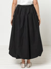 Person wearing a black skirt and white top made using Sophia Woven Bubble Skirt and Pant sewing pattern on a white background