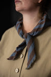 Person wearing a striped scarf with a dark background