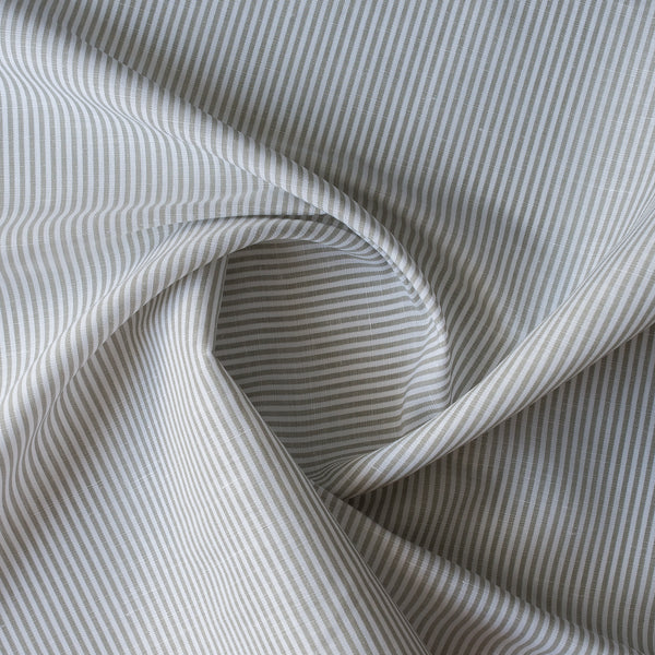 Close-up of Whisper Moss Stripe linen–organic cotton fabric with thin eucalyptus green stripes on white, 140 GSM.