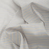 Playful vertical stripes in white and mustard on a light purple-toned grey linen-cotton blend fabric