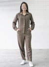 A trendy Melrose boiler suit sewing pattern with a button fly front, long sleeves, and practical pockets, suitable for durable fabrics like denim and linen.